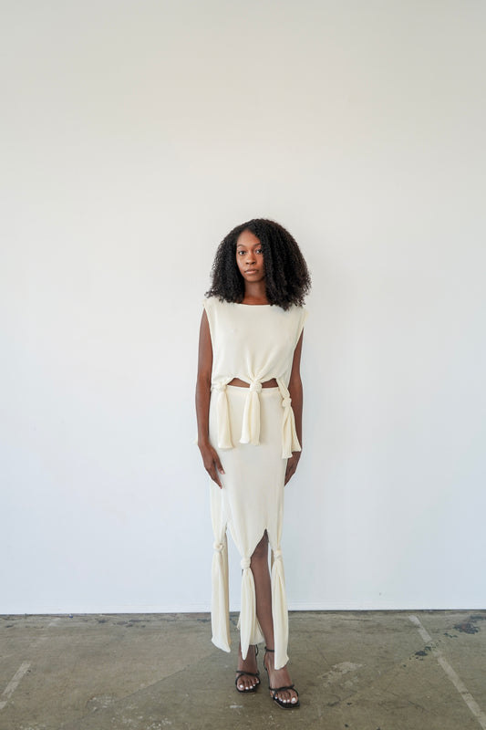 Model wearing Robin Top tied at the waist – pleated crop top with sculptural plissé fabric and boat neck