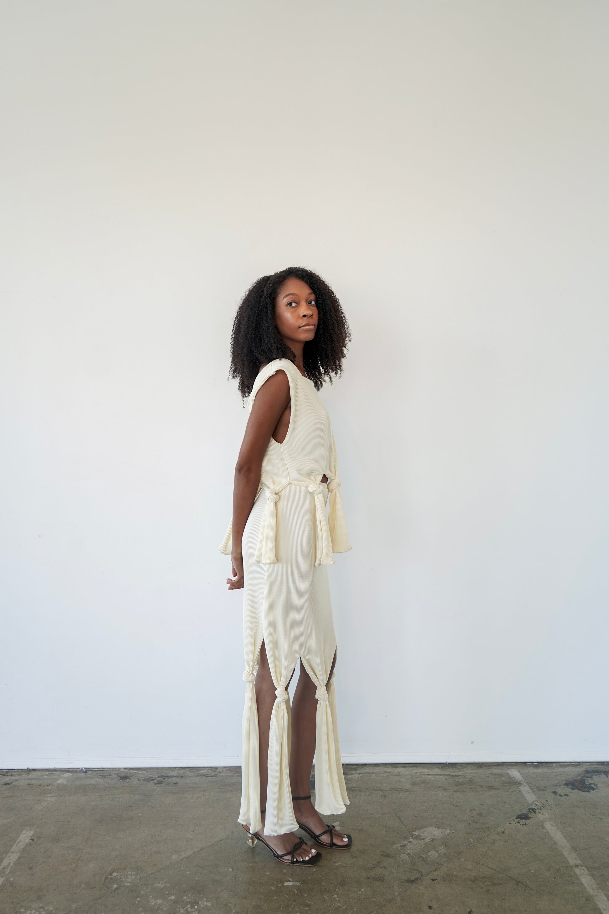 Side view of Robin Top – cropped plissé top with boat neckline and flowing untied front